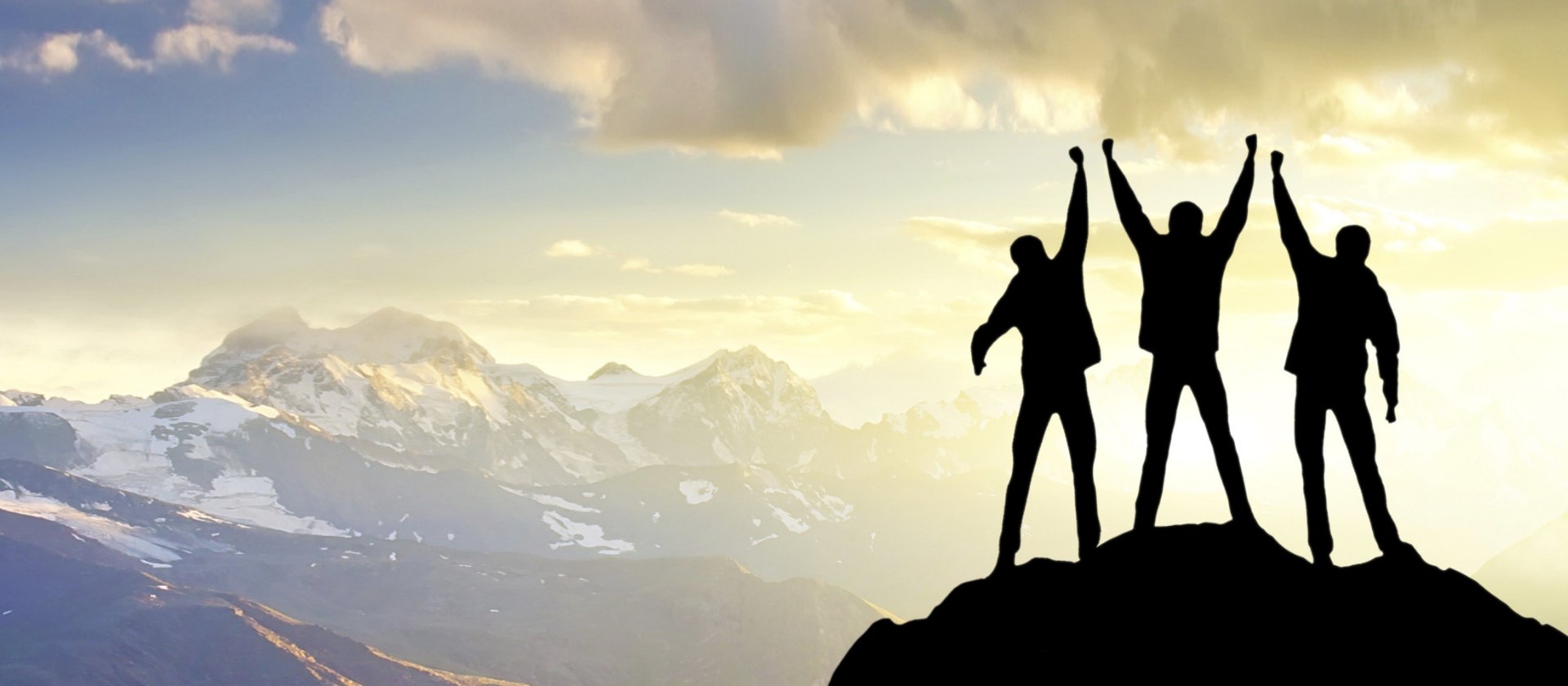 Three men are standing on the mountain top and watching the sunrise.