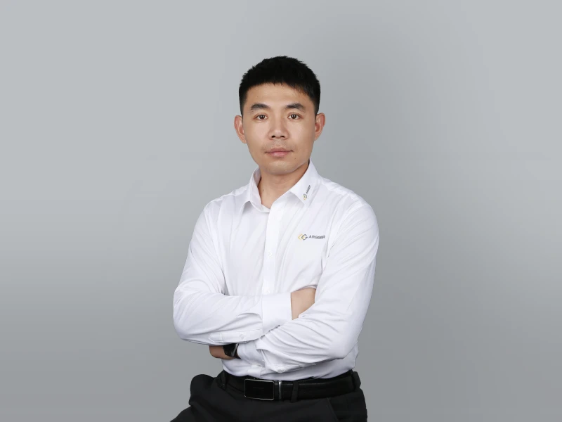 Robert, dressed in white, with his arms crossed in front of his chest